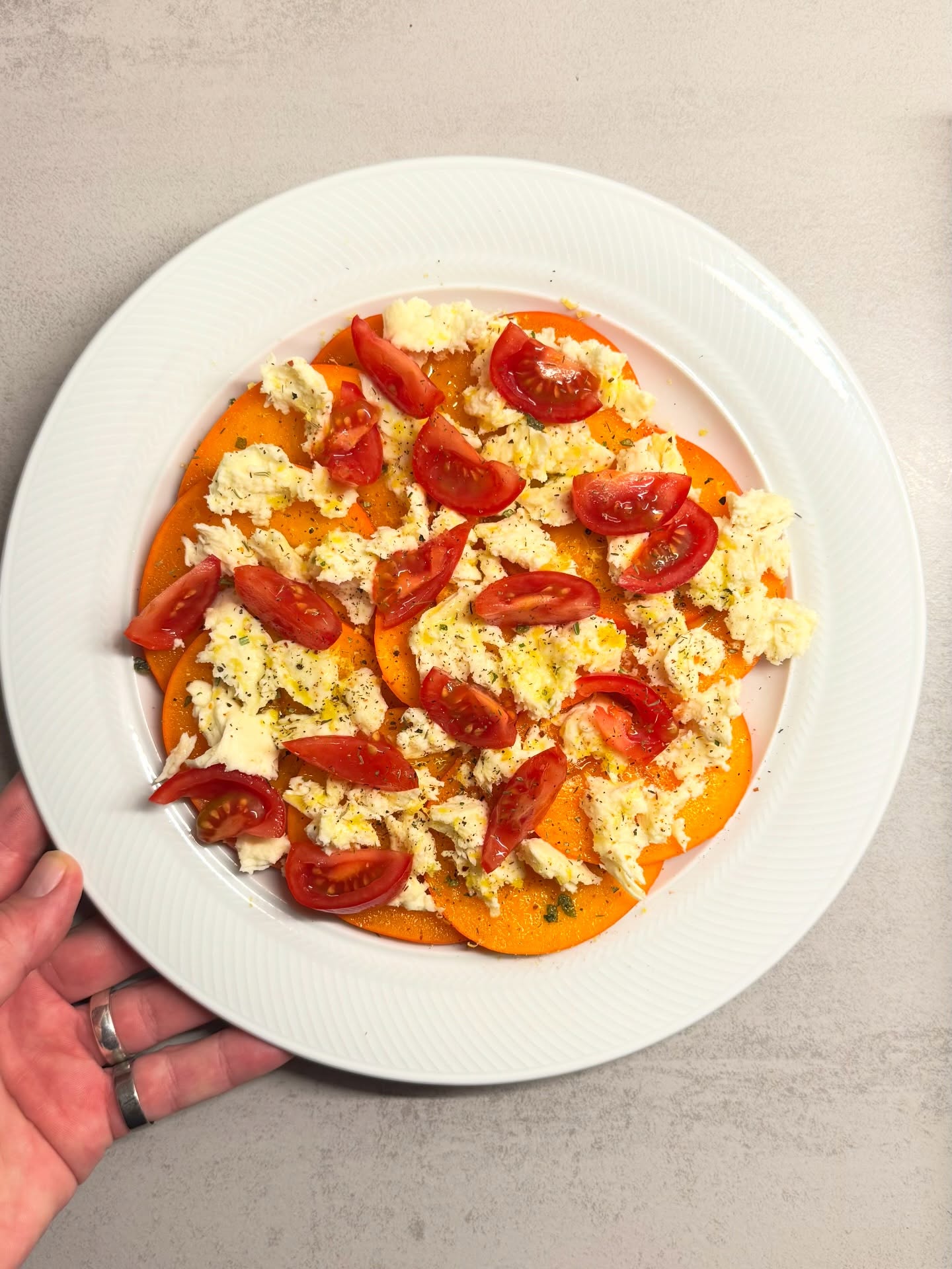 Conny hatte im Netz gesehen, das jemand Caprese mit Kaki und Mozzarella gegessen hat und wollte das mal ausprobieren.  Dazu die Kaki mit Schale in dünne Scheiben schneiden, den Mozzarella in kleine Stücke zupfen und auf den Scheiben verteilen.  Das Ganze mit etwas Olivenöl beträufeln, mit Basilikum-Salz und etwas Abrieb einer Zitrone würzen. Etwas Rosmarin rundet dieses leichte Gericht perfekt ab.  Hätte ich paar Walnüsse zur Hand gehabt, hätten diese sicher etwas angeröstet super dazu gepasst.  #caprese #kaki #mozarella #olivenöl #leichtegerichte #vorspeise #kalteküche